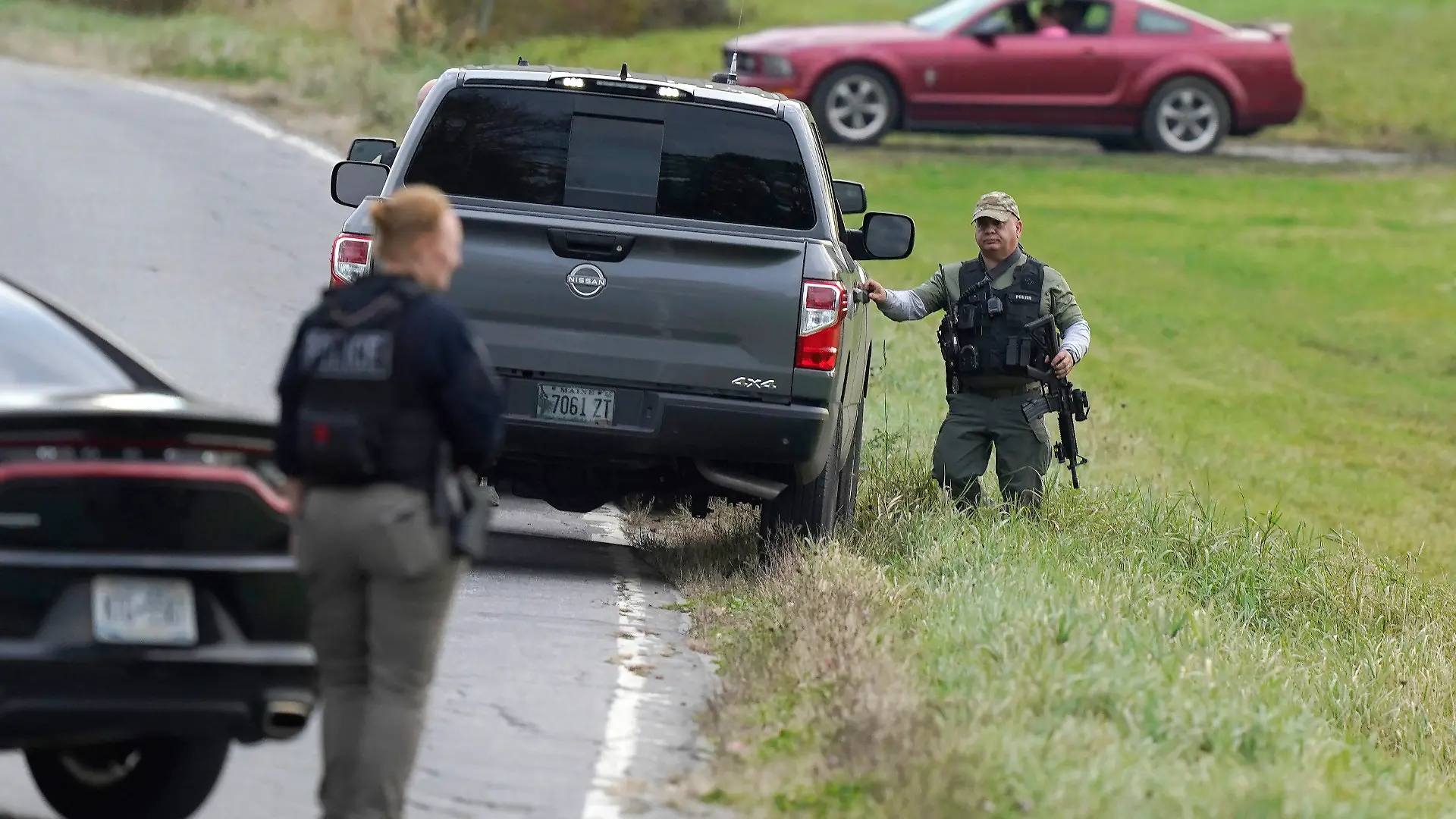 26.10.2023, USA, Bowdoin: Polizisten halten Gewehre in der Hand, während sie einen Bereich in Bowdoin, Maine, untersuchen. Bei der Suche nach dem Todesschützen von Maine hat die US-Polizei hier mehrere Häuser durchsucht. Bowdoin ist etwa eine halbe Stunde mit dem Auto von Lewiston entfernt, wo ein Schütze am Mittwochabend (Ortszeit) mindestens 18 Menschen mit einem Sturmgewehr getötet hatte. Foto: Steven Senne/AP/dpa +++ dpa-Bildfunk +++