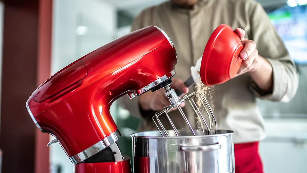 Chef pouring ingredients into a mixing bowl