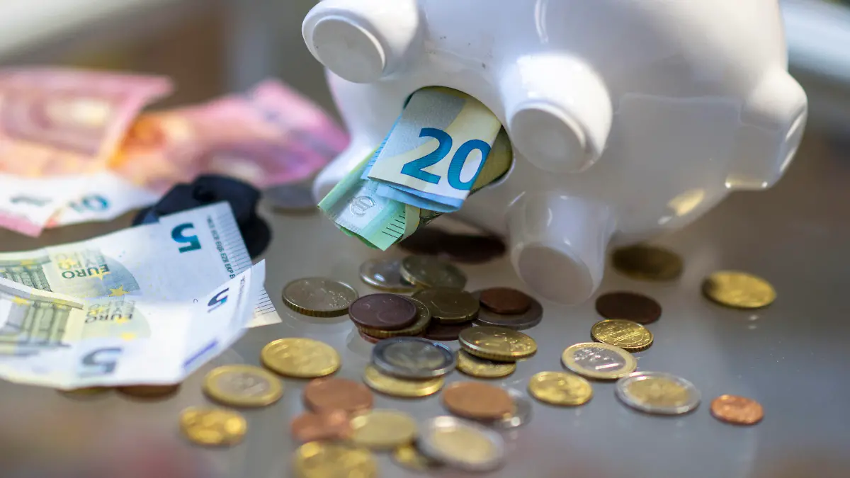 ILLUSTRATION - 23.10.2023, Sachsen, Leipzig: Geld steckt im Bauch eines Sparschweins. Am 30. Oktober 2023 ist Weltspartag. Foto: Hendrik Schmidt/dpa +++ dpa-Bildfunk +++