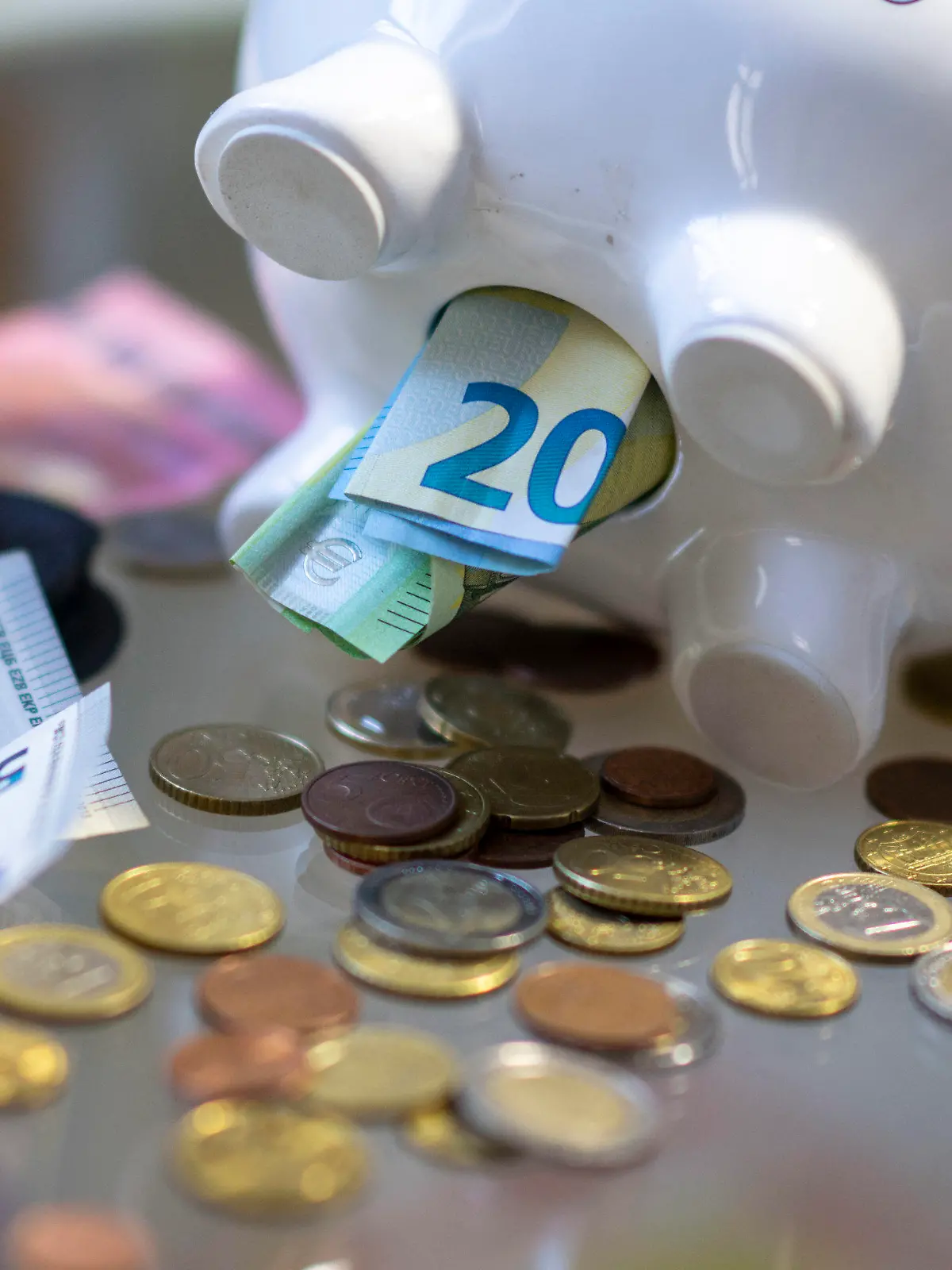 ILLUSTRATION - 23.10.2023, Sachsen, Leipzig: Geld steckt im Bauch eines Sparschweins. Am 30. Oktober 2023 ist Weltspartag. Foto: Hendrik Schmidt/dpa +++ dpa-Bildfunk +++