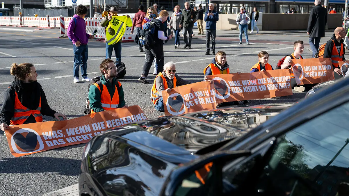 03.11.2022, Bayern, München: Klimaaktivisten haben sich am Karlsplatz in der Münchner Innenstadt auf die Fahrbahn geklebt und blockieren die Straße. Foto: Lennart Preiss/dpa +++ dpa-Bildfunk +++