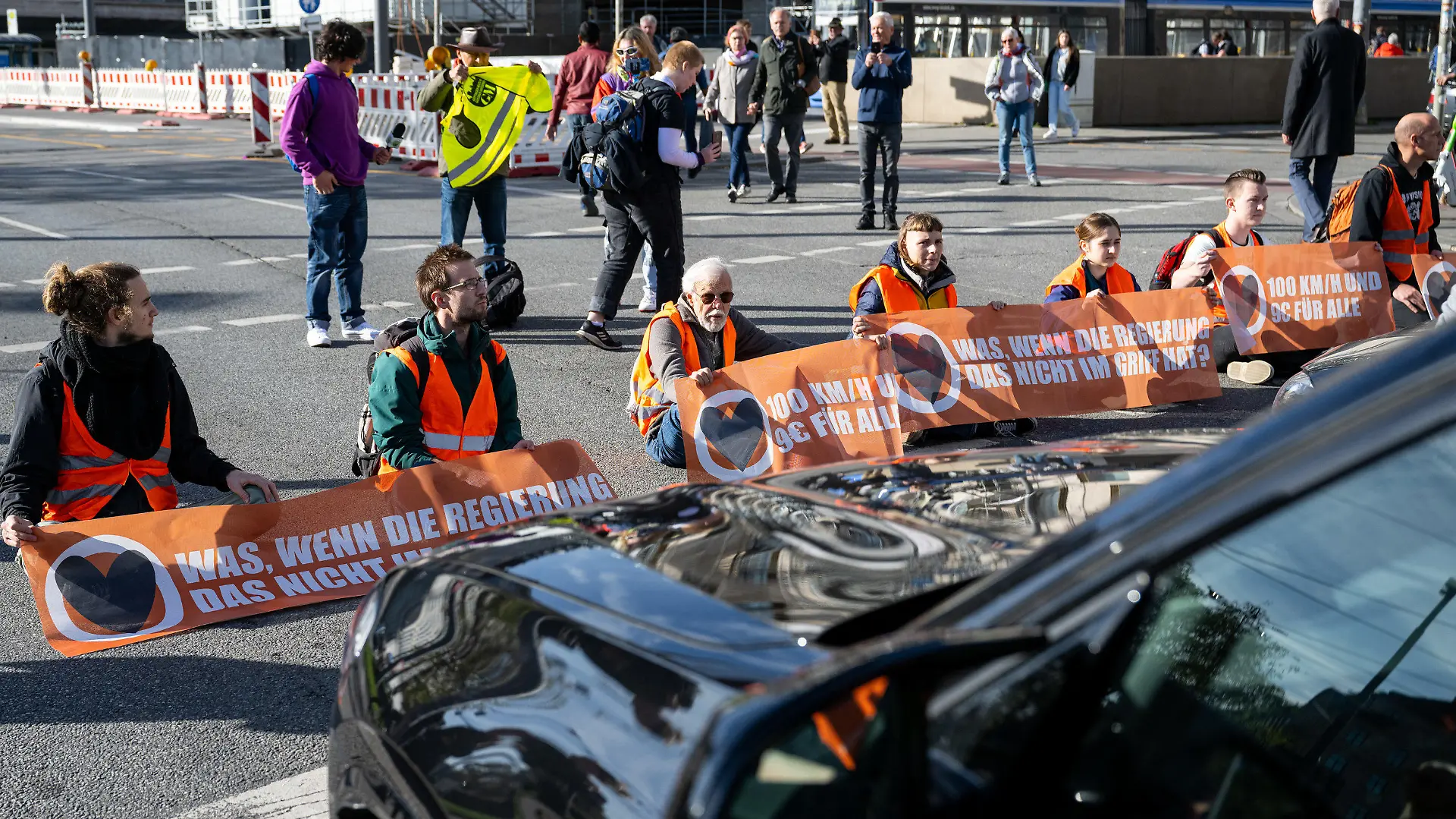 03.11.2022, Bayern, München: Klimaaktivisten haben sich am Karlsplatz in der Münchner Innenstadt auf die Fahrbahn geklebt und blockieren die Straße. Foto: Lennart Preiss/dpa +++ dpa-Bildfunk +++