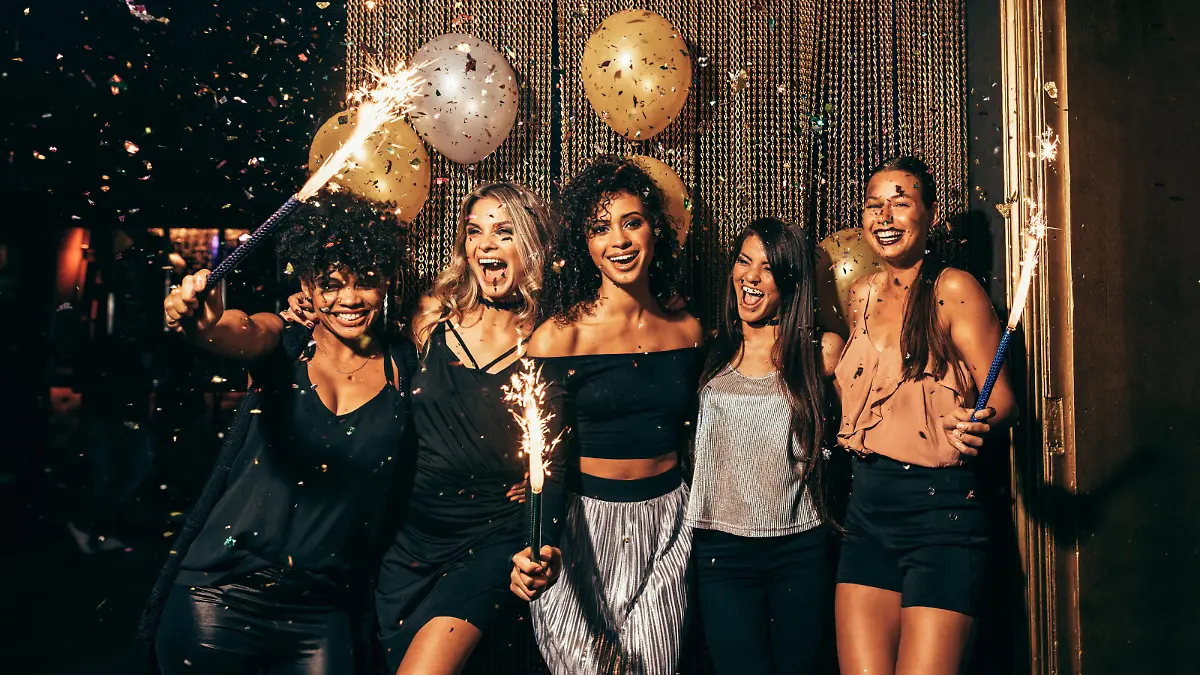 Shot of group of young women celebrating new years eve at the pub. Group of female friends with sparklers partying in nightclub.