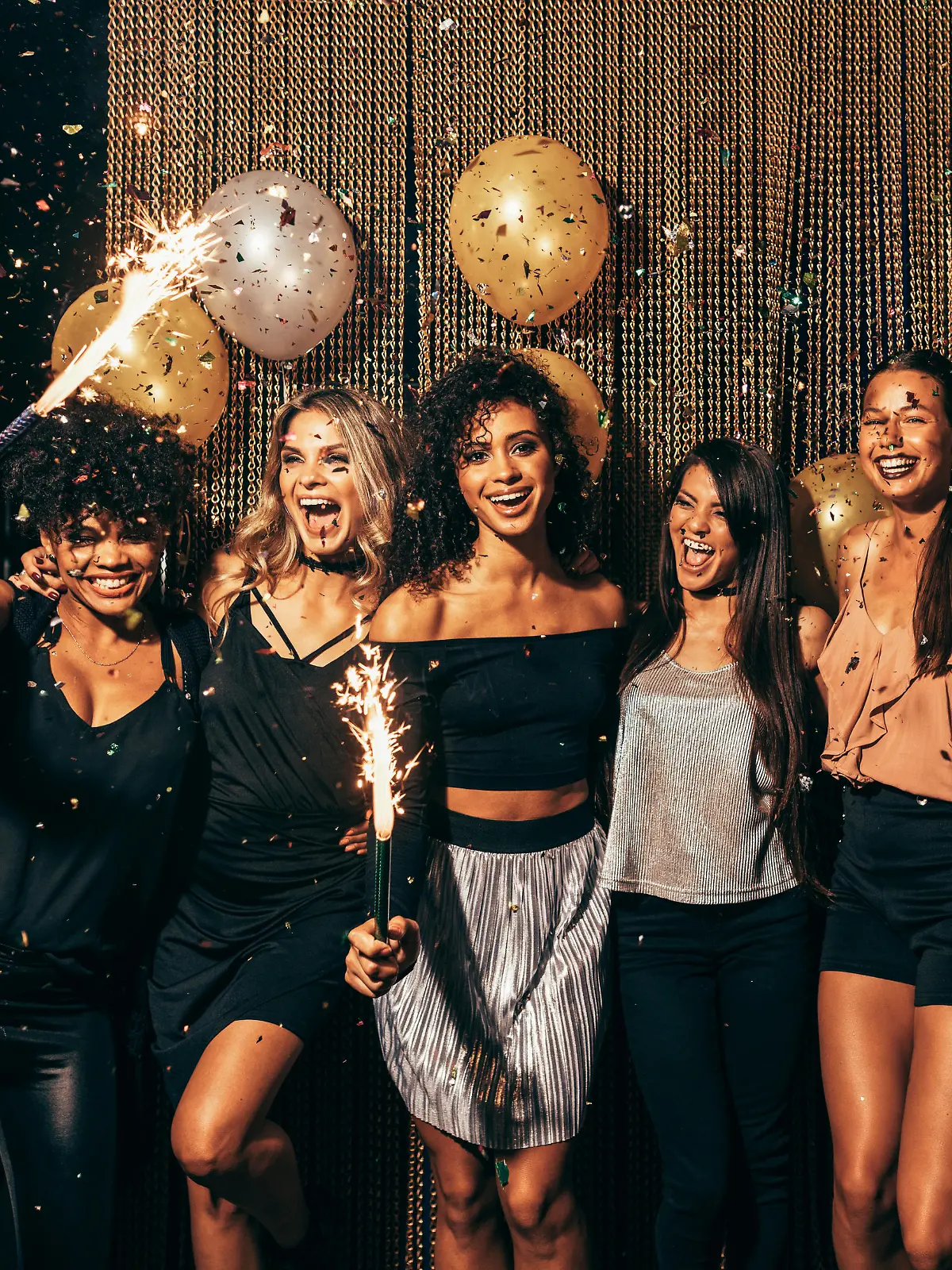 Shot of group of young women celebrating new years eve at the pub. Group of female friends with sparklers partying in nightclub.