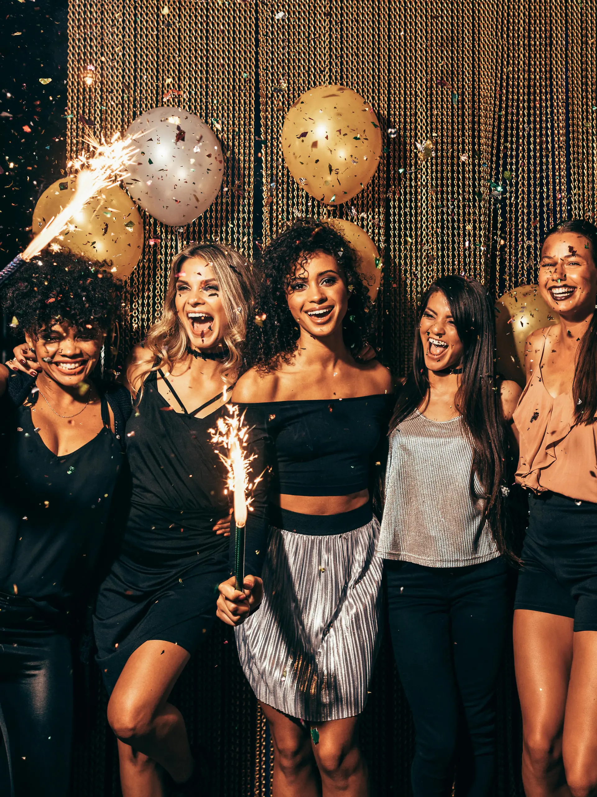Shot of group of young women celebrating new years eve at the pub. Group of female friends with sparklers partying in nightclub.