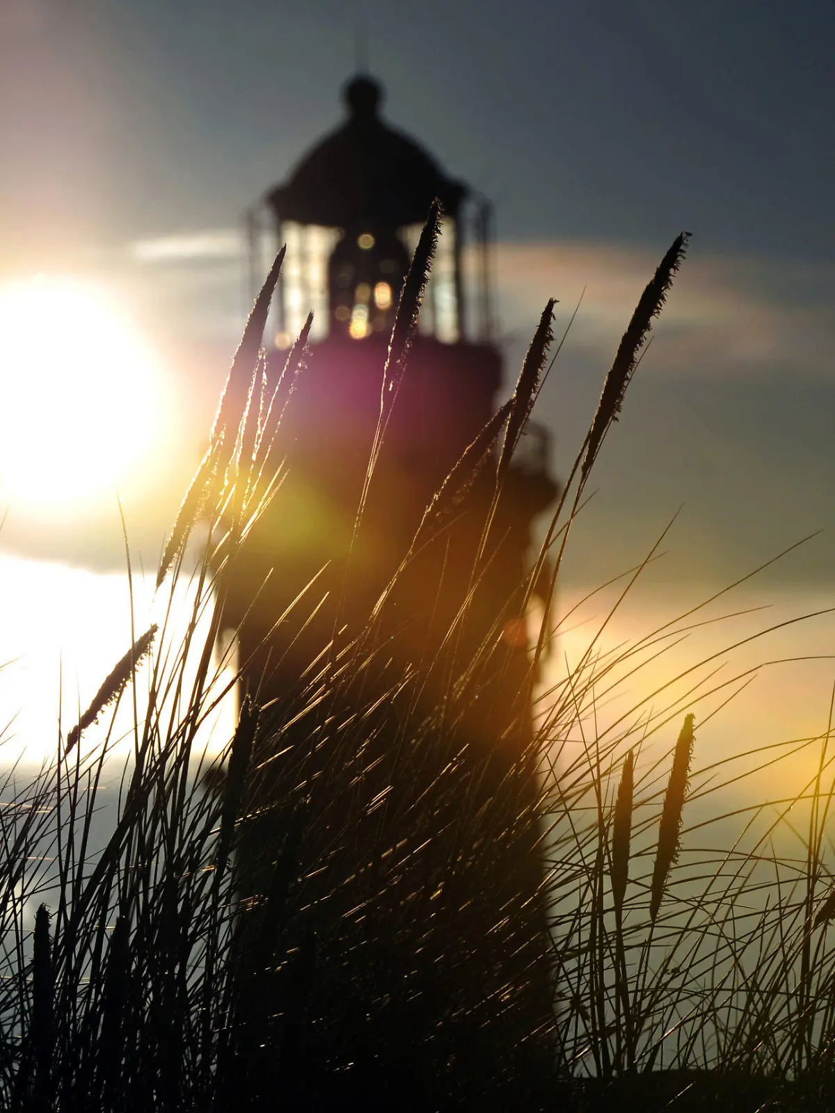 Die Sonne scheint am Dienstag (03.07.2012) in Wittdün (Kreis Nordfriesland) durch den Leuchtturm Amrum. Am Sonntag ist der zehnjährige Sebastian auf der Nordseeinsel Amrum verschwunden. Seitdem wird intensiv nach ihm gesucht. Foto: Daniel Reinhardt dpa/lno  +++(c) dpa - Bildfunk+++
