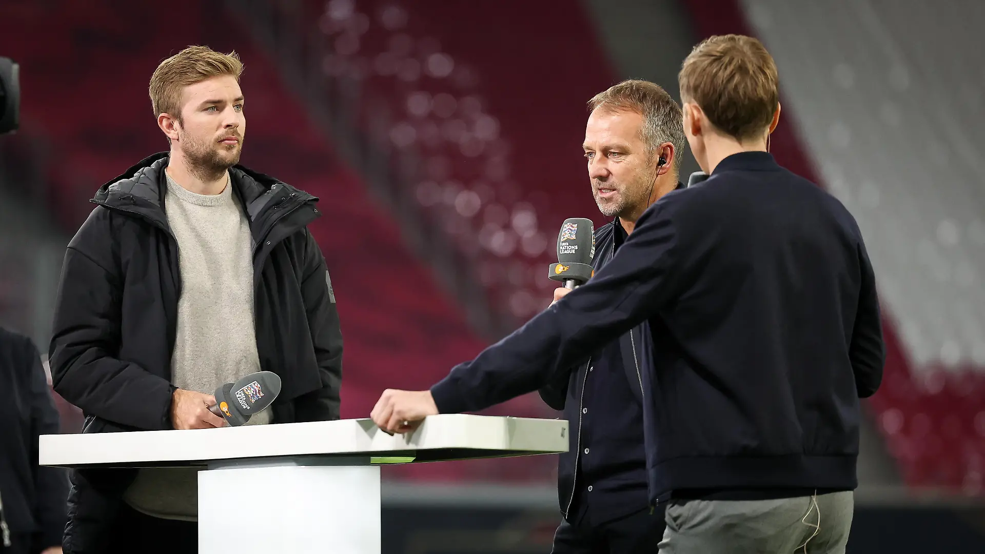Fußball: Nations League A, Deutschland - Ungarn, Gruppenphase, Gruppe 3, 5. Spieltag, Red Bull Arena. Christoph Kramer (l-r), Fußballspieler und TV-Experte, Bundestrainer Hansi Flick und Jochen Breyer, Moderator ZDF Sport, bei einer Interviewrunde nach dem Spiel im Stadion.