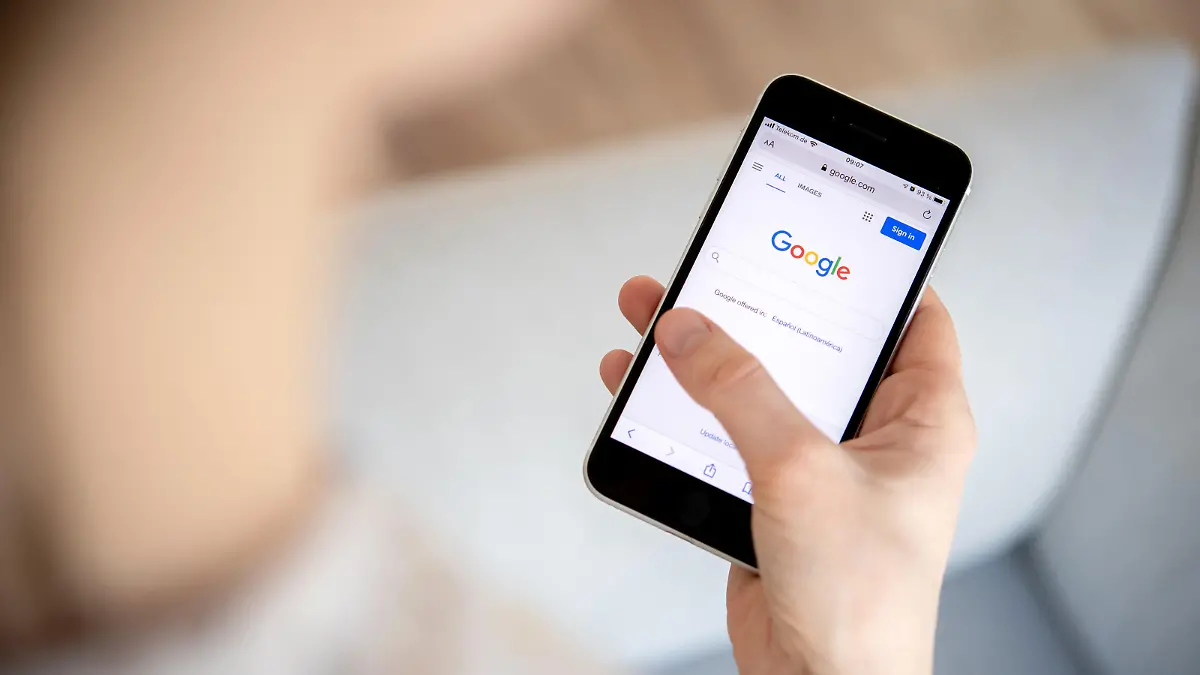 26.03.2022, Niedersachsen, Oldenburg: Eine Frau hält ein iPhone in der Hand und benutzt die Internet-Suchmaschine Google. Foto: Hauke-Christian Dittrich