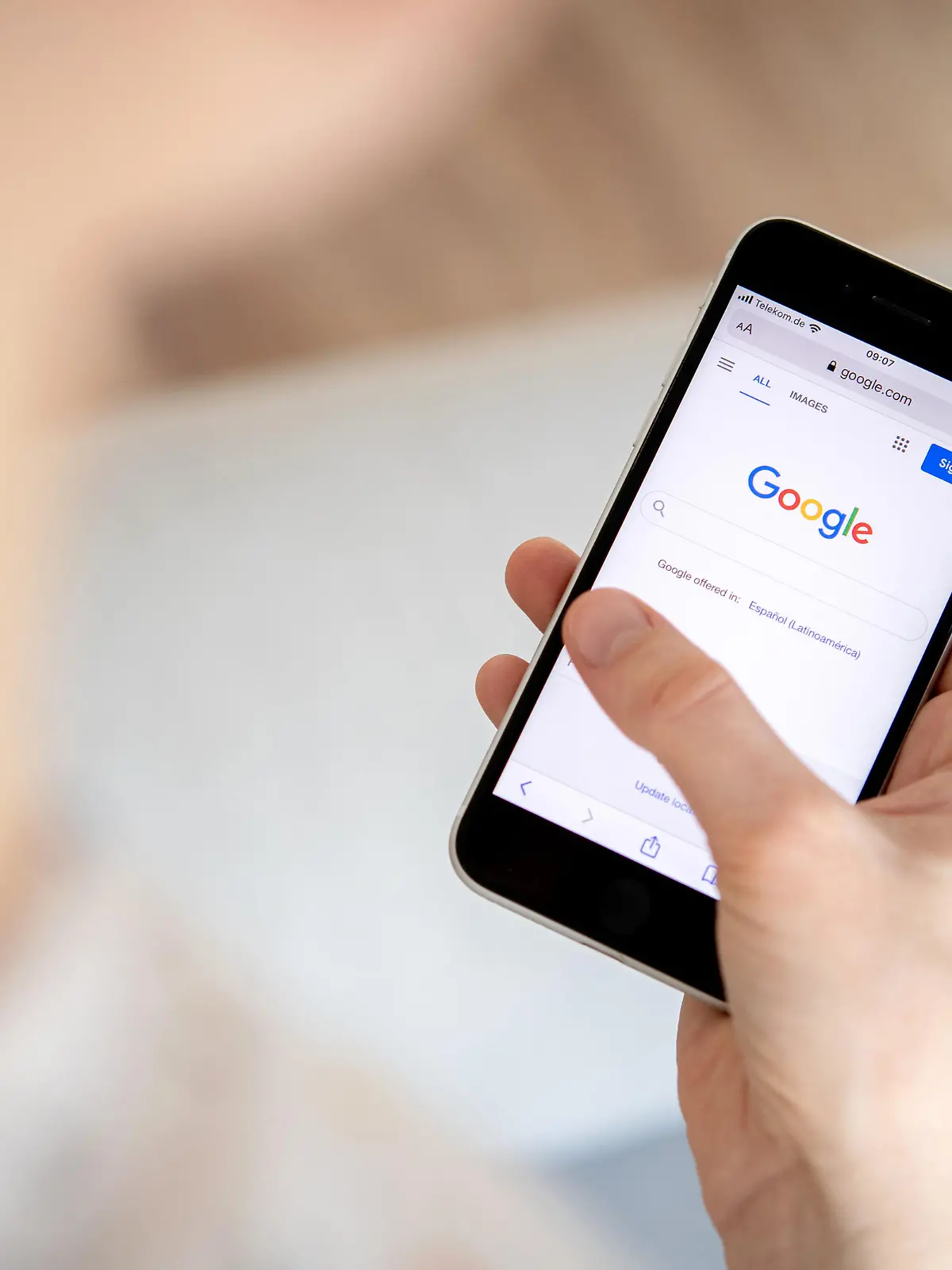 26.03.2022, Niedersachsen, Oldenburg: Eine Frau hält ein iPhone in der Hand und benutzt die Internet-Suchmaschine Google. Foto: Hauke-Christian Dittrich