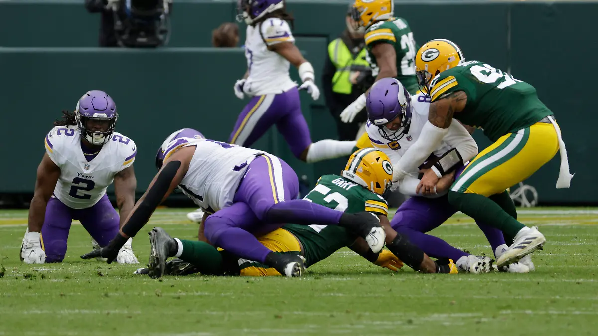 Minnesota Vikings quarterback Kirk Cousins (8) is tackled by Green Bay Packers linebacker Rashan Gary (52), middle left, and linebacker Preston Smith (91), right, during the second half of an NFL football game Sunday, Oct. 29, 2023, in Green Bay, Wis. (AP Photo/Mike Roemer)