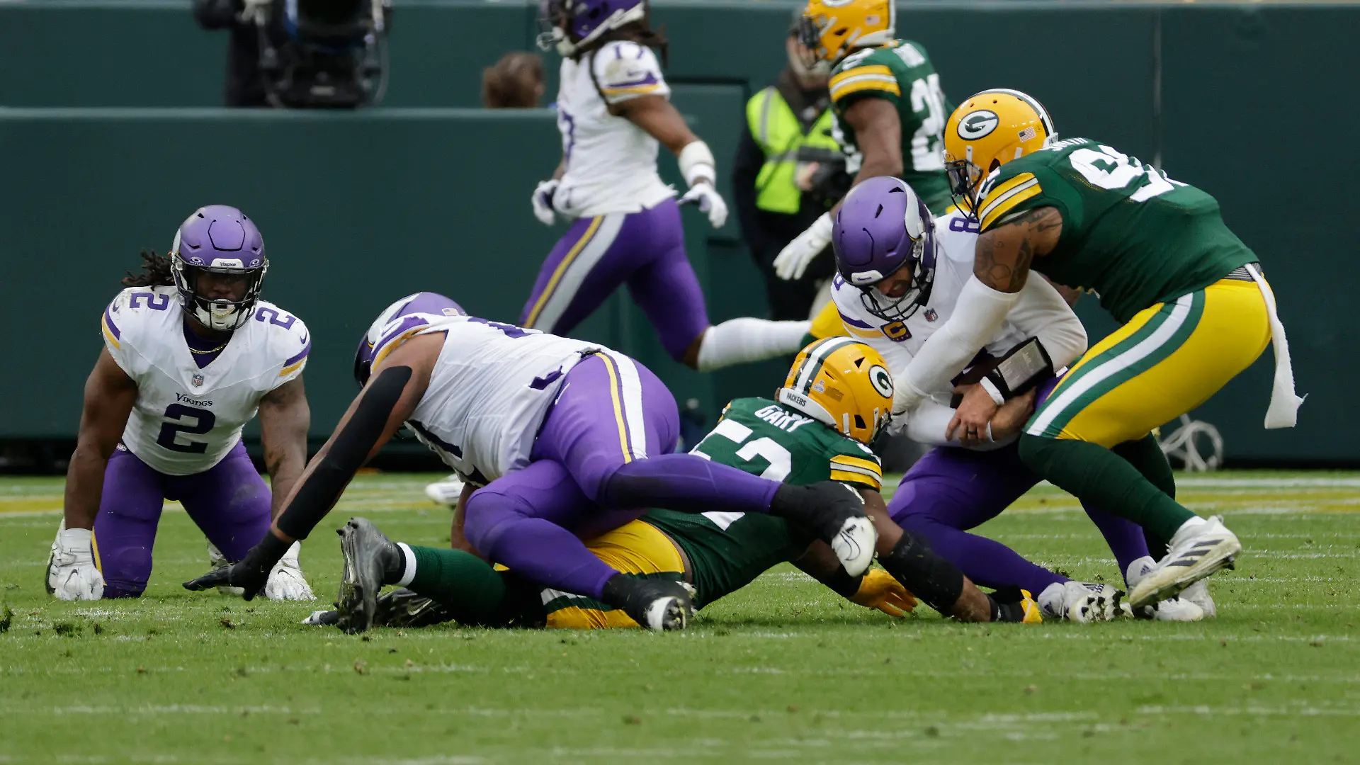 Minnesota Vikings quarterback Kirk Cousins (8) is tackled by Green Bay Packers linebacker Rashan Gary (52), middle left, and linebacker Preston Smith (91), right, during the second half of an NFL football game Sunday, Oct. 29, 2023, in Green Bay, Wis. (AP Photo/Mike Roemer)