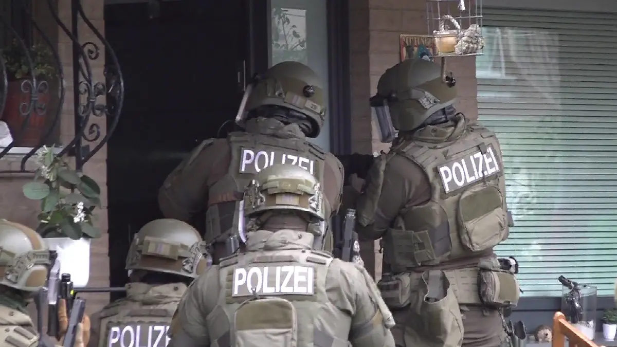 SEK-Einsatz in Hannover: Mit gezückten Waffen stehen die Polizisten vor einem Wohnhaus.