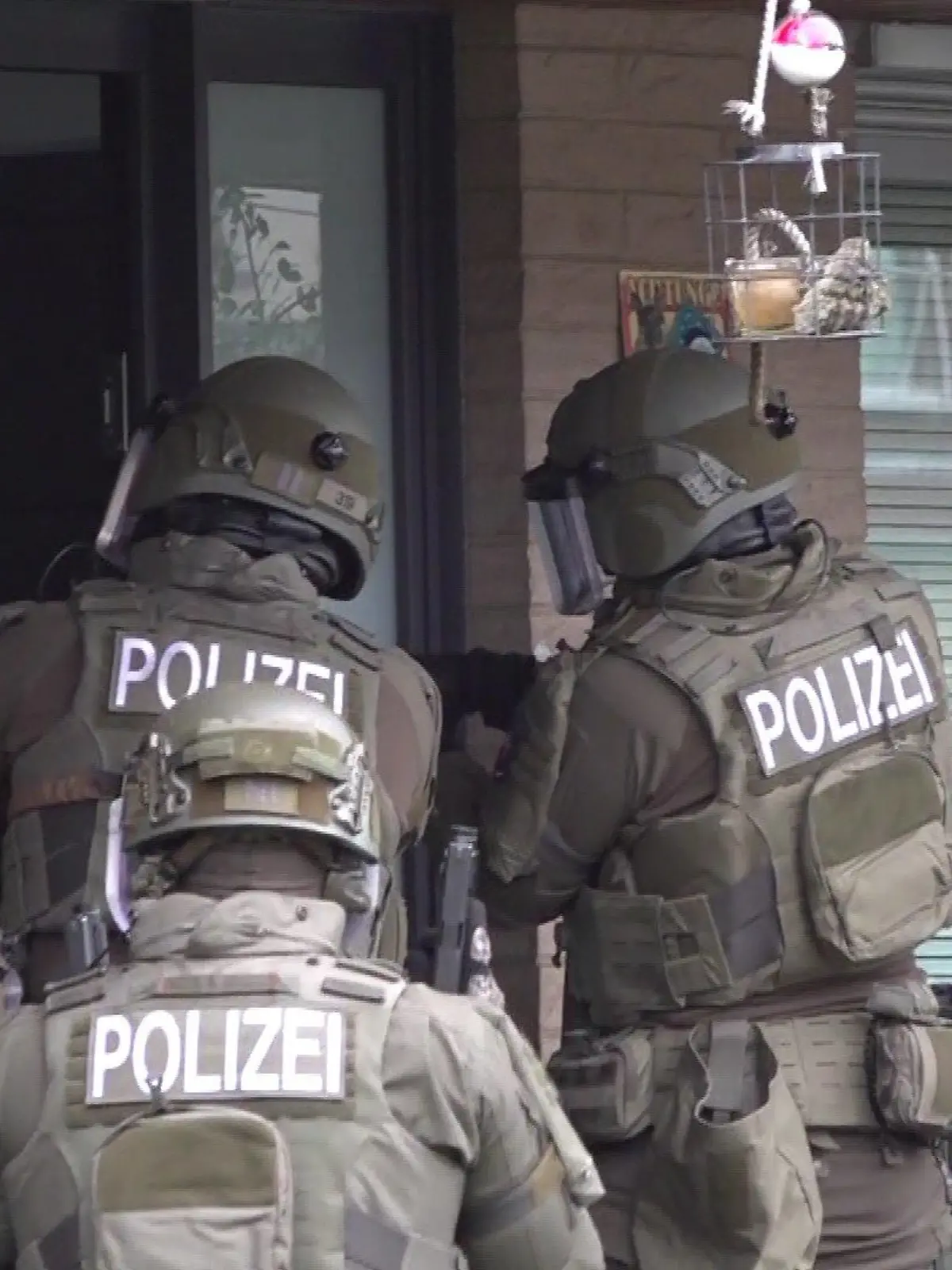 SEK-Einsatz in Hannover: Mit gezückten Waffen stehen die Polizisten vor einem Wohnhaus.