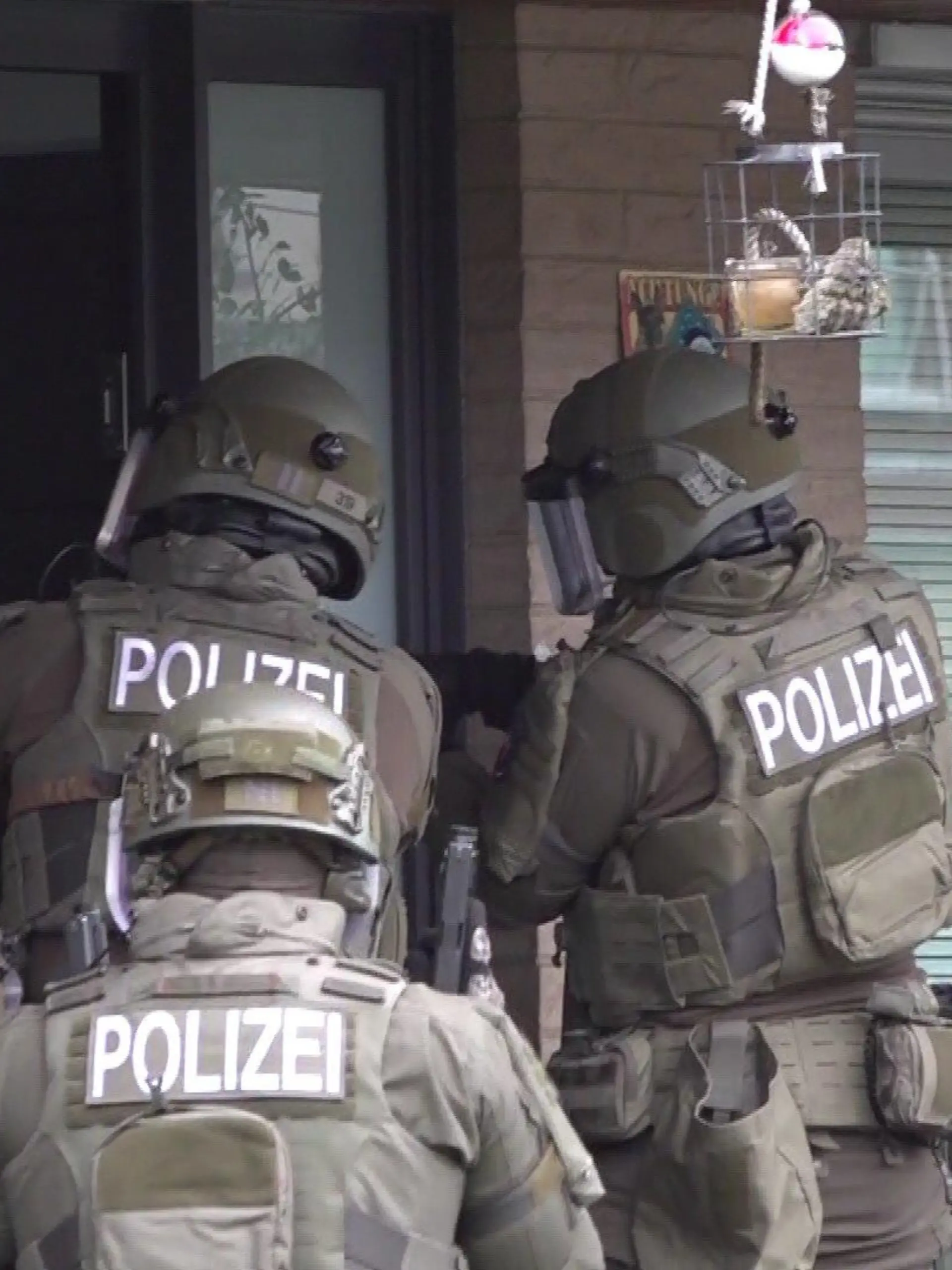 SEK-Einsatz in Hannover: Mit gezückten Waffen stehen die Polizisten vor einem Wohnhaus.