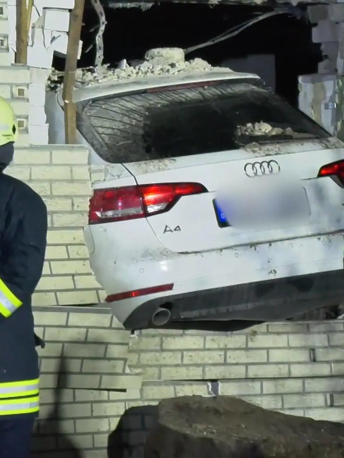 Das Auto rast in die Hauswand und bleibt stecken.