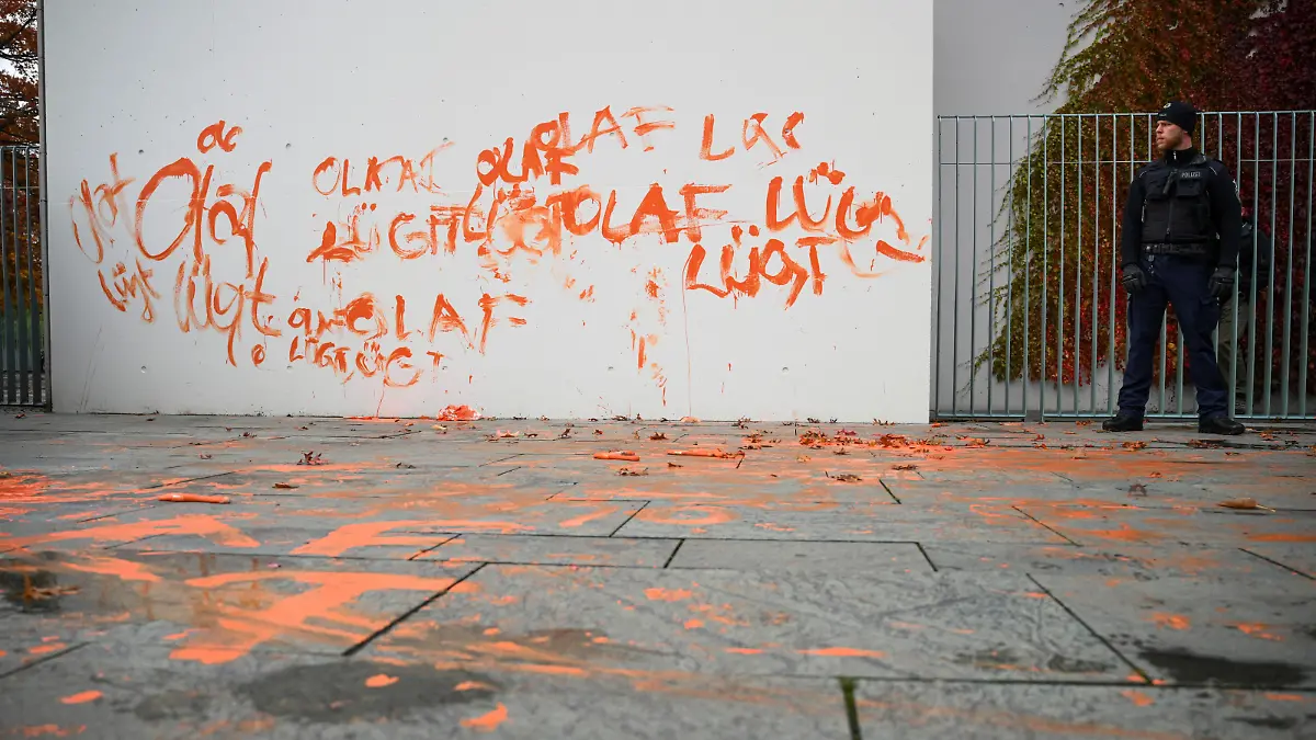 A police officer guards a painted part of the Chancellery wall by activists of the 'Letzte Generation' (Last Generation) to protest in Berlin, Germany October 31, 2023. REUTERS/Annegret Hilse