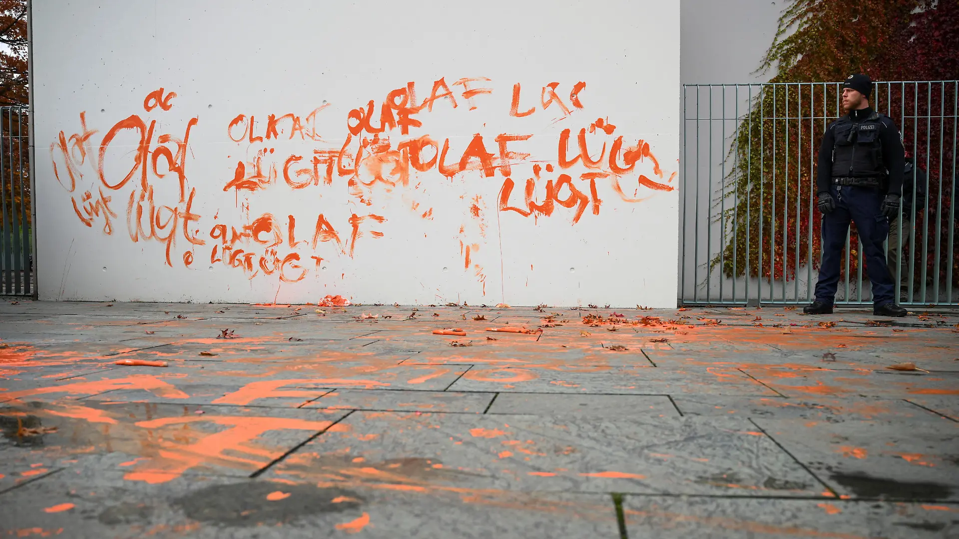 A police officer guards a painted part of the Chancellery wall by activists of the 'Letzte Generation' (Last Generation) to protest in Berlin, Germany October 31, 2023. REUTERS/Annegret Hilse