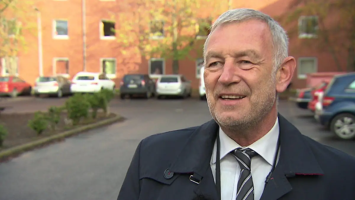 Manfred Becker steht vor einer Erstaufnahmeeinrichtung für Geflüchtete.