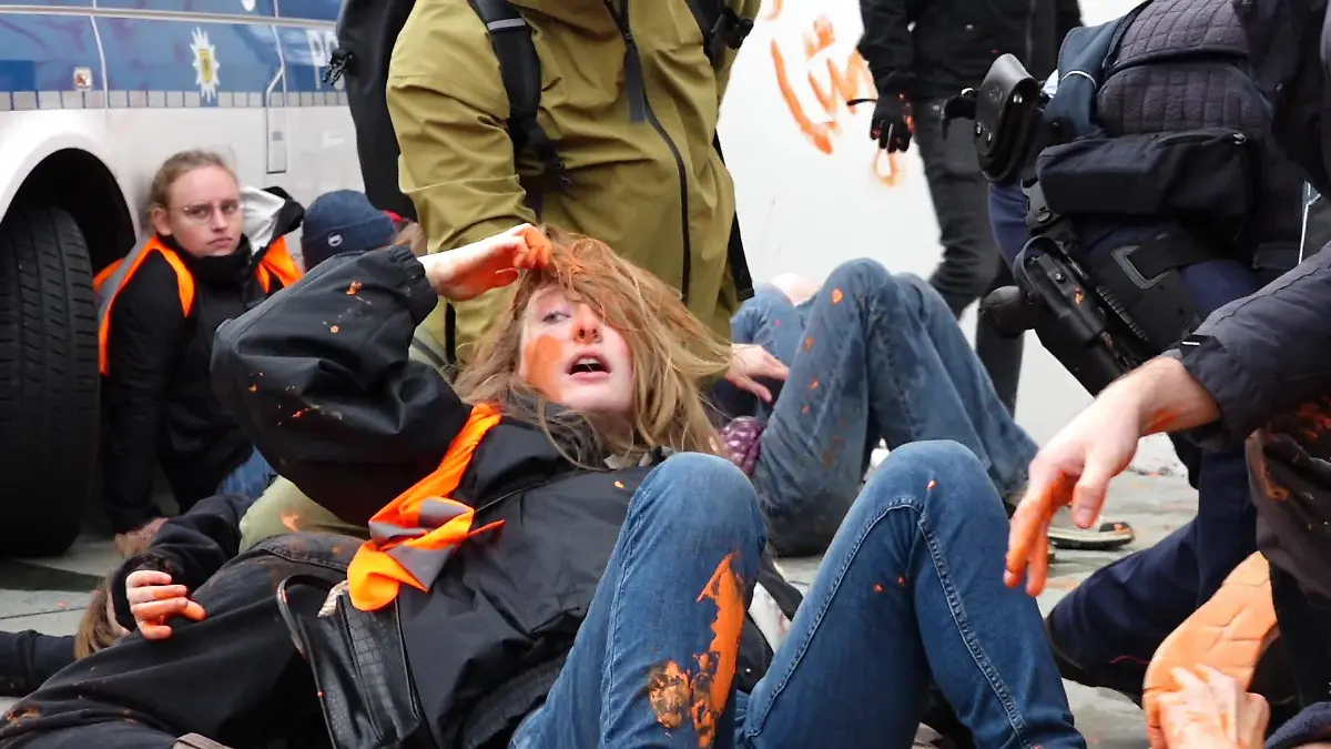 Eine Aktivistin der Letzten Generation unmittelbar nach der Farb-Attacke in ihr Gesicht.