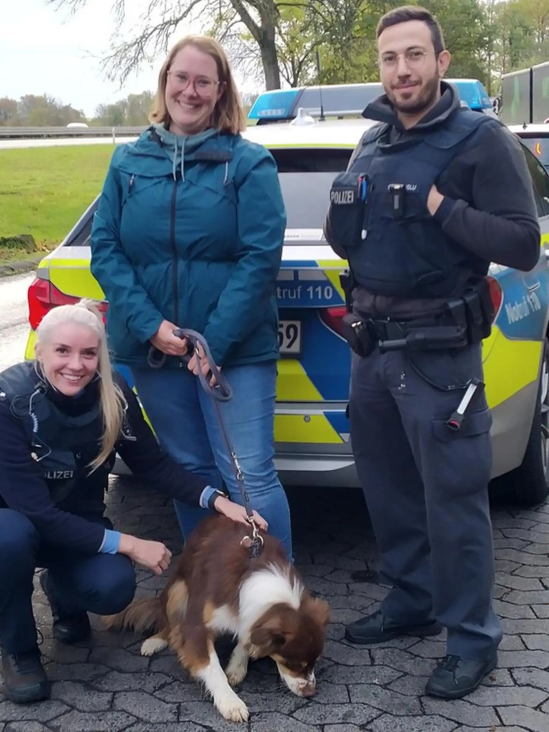 Hündin Telly, Polizisten und ihre Besitzerin posieren für ein Foto.