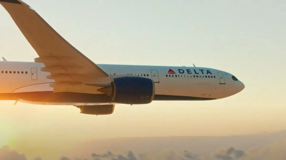 Ein Flugzeug von Delta Airlines fliegt Richtung Sonnenuntergang.