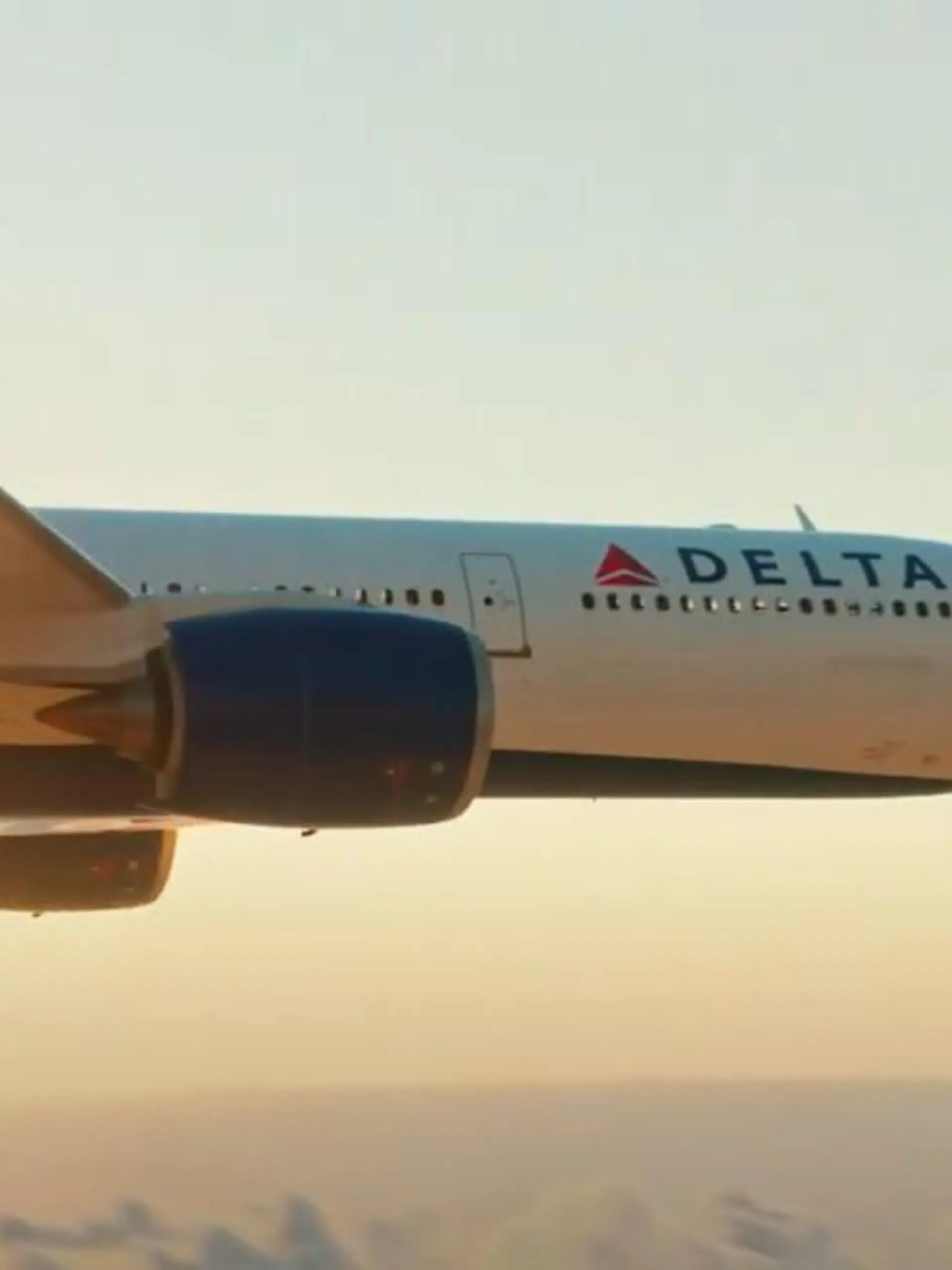 Ein Flugzeug von Delta Airlines fliegt Richtung Sonnenuntergang.