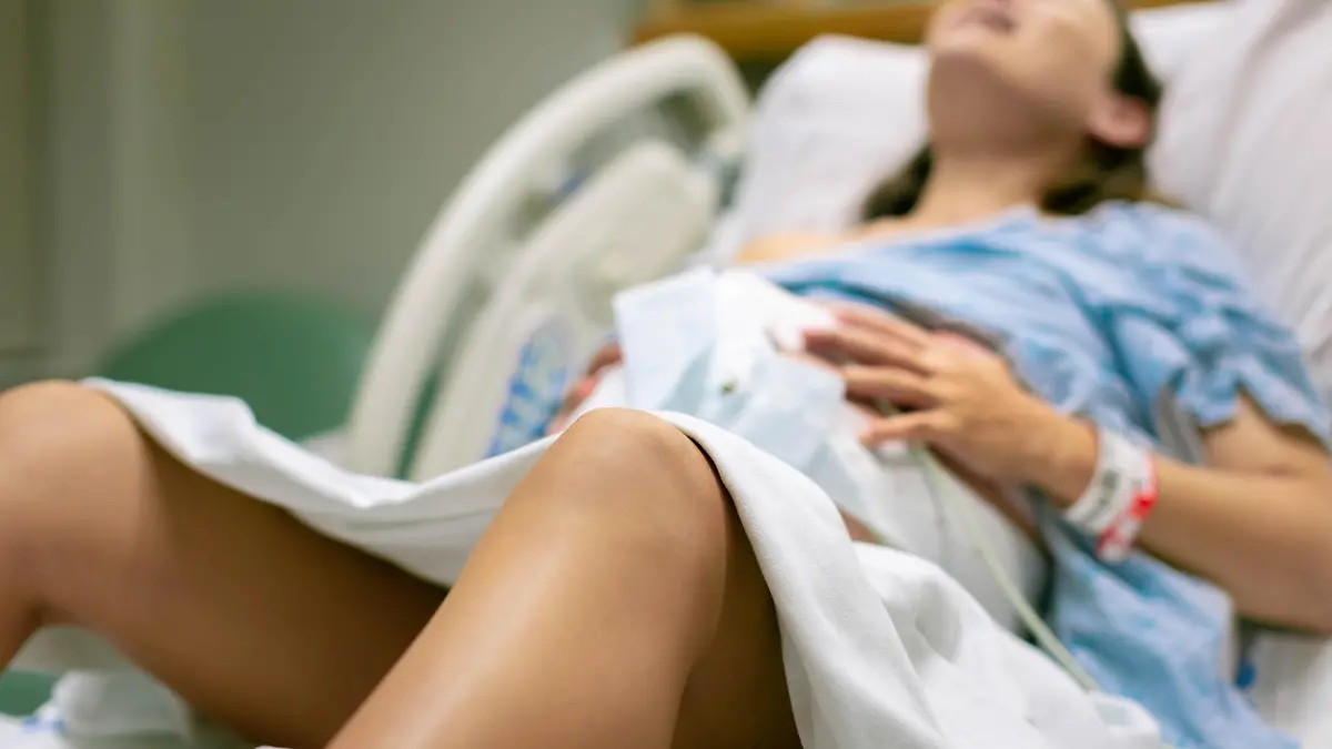 A woman screaming in pain from strong contractions. Childbirth.