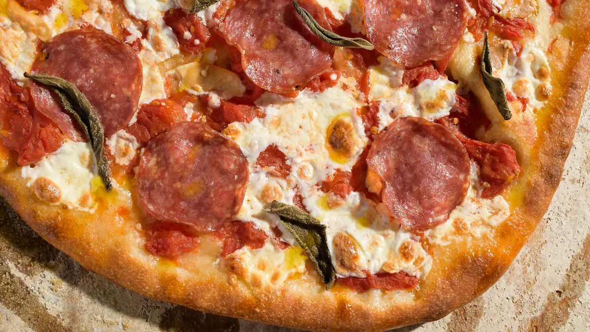 This image released by Milk Street shows a recipe for pizza with salami and smoked mozzarella. (Milk Street via AP)