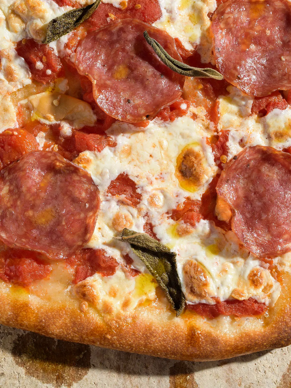 This image released by Milk Street shows a recipe for pizza with salami and smoked mozzarella. (Milk Street via AP)