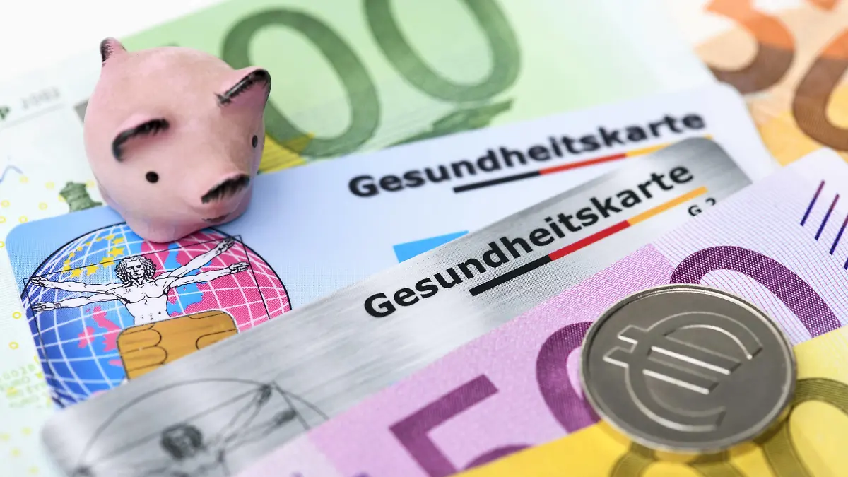  Gesundheitskarten mit Geldscheinen und Sparschwein, Krankenkassenbeiträge *** Health cards with money and piggy bank health insurance contributions