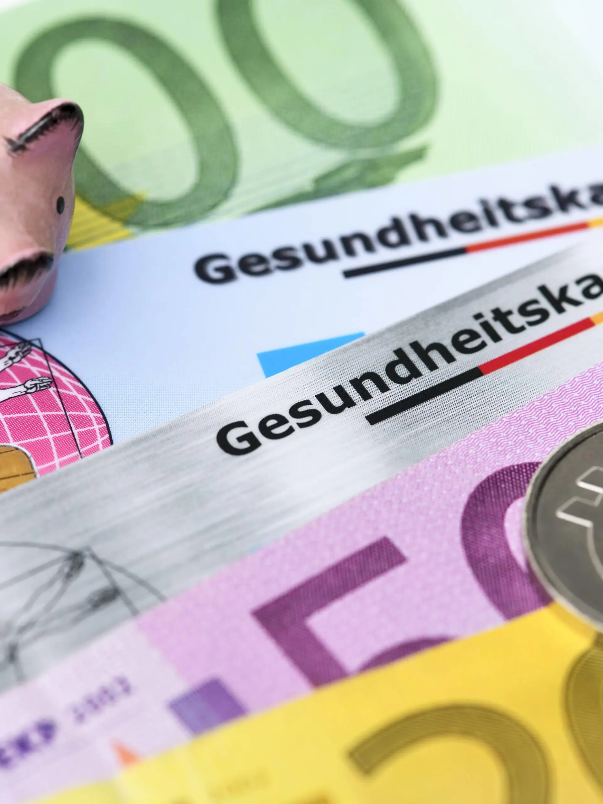  Gesundheitskarten mit Geldscheinen und Sparschwein, Krankenkassenbeiträge *** Health cards with money and piggy bank health insurance contributions