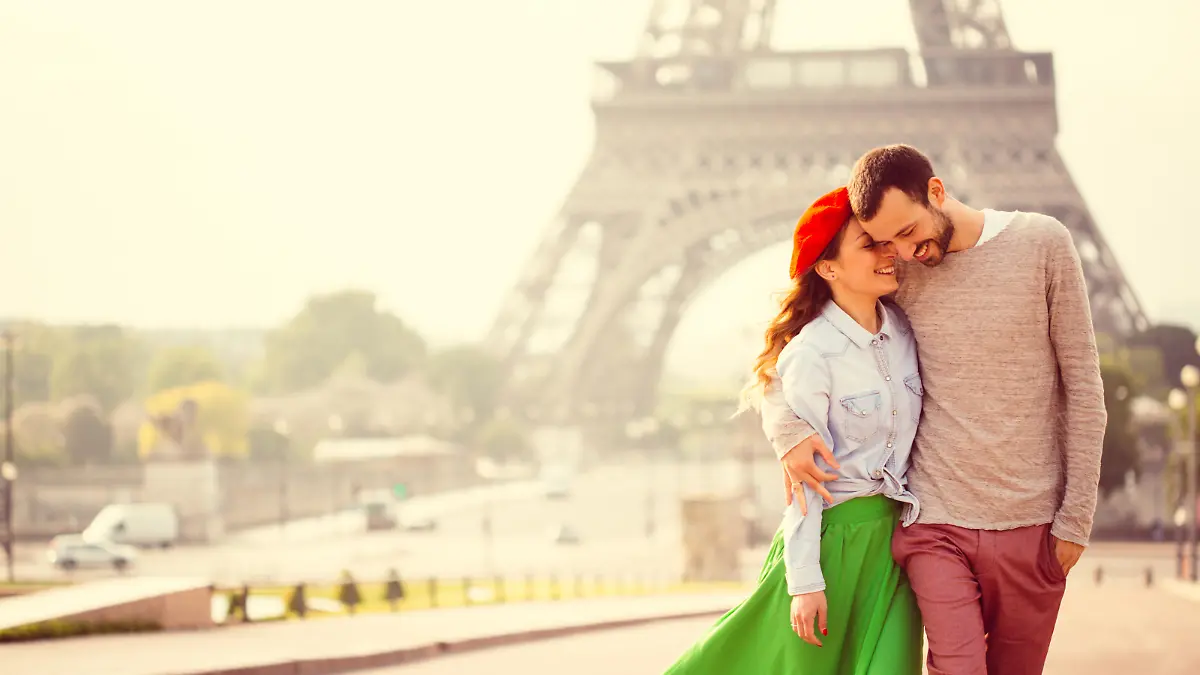 Young loving couple sharing their love and affection in front of the Eiffel tower in Paris, France. 