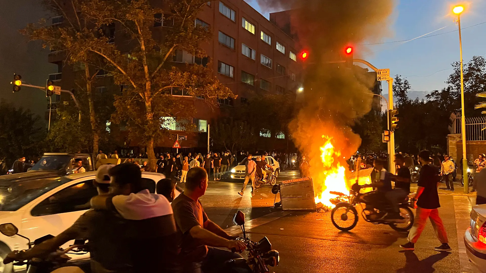 19.09.2022, Iran, Teheran: Auf diesem Foto vom Montag, 19. September 2022, das von einer nicht bei Associated Press angestellten Person aufgenommen und von AP außerhalb des Irans beschafft wurde, brennen ein Polizeimotorrad und ein Mülleimer während eines Protests gegen den Tod von Mahsa Amini, einer 22-jährigen Frau, die von der Sittenpolizei des Landes inhaftiert worden war, in der Innenstadt von Teheran. Studierende haben an verschiedenen Universitäten im Iran ihren Protest gegen den repressiven Führungskurs des Landes fortgesetzt. An mehreren Hochschulen der Hauptstadt Teheran zeigten junge Frauen und Männer am Montag ihren Unmut gegen das islamische Regierungssystem, wie iranische Medien berichteten. Foto: Uncredited/AP/dpa +++ dpa-Bildfunk +++