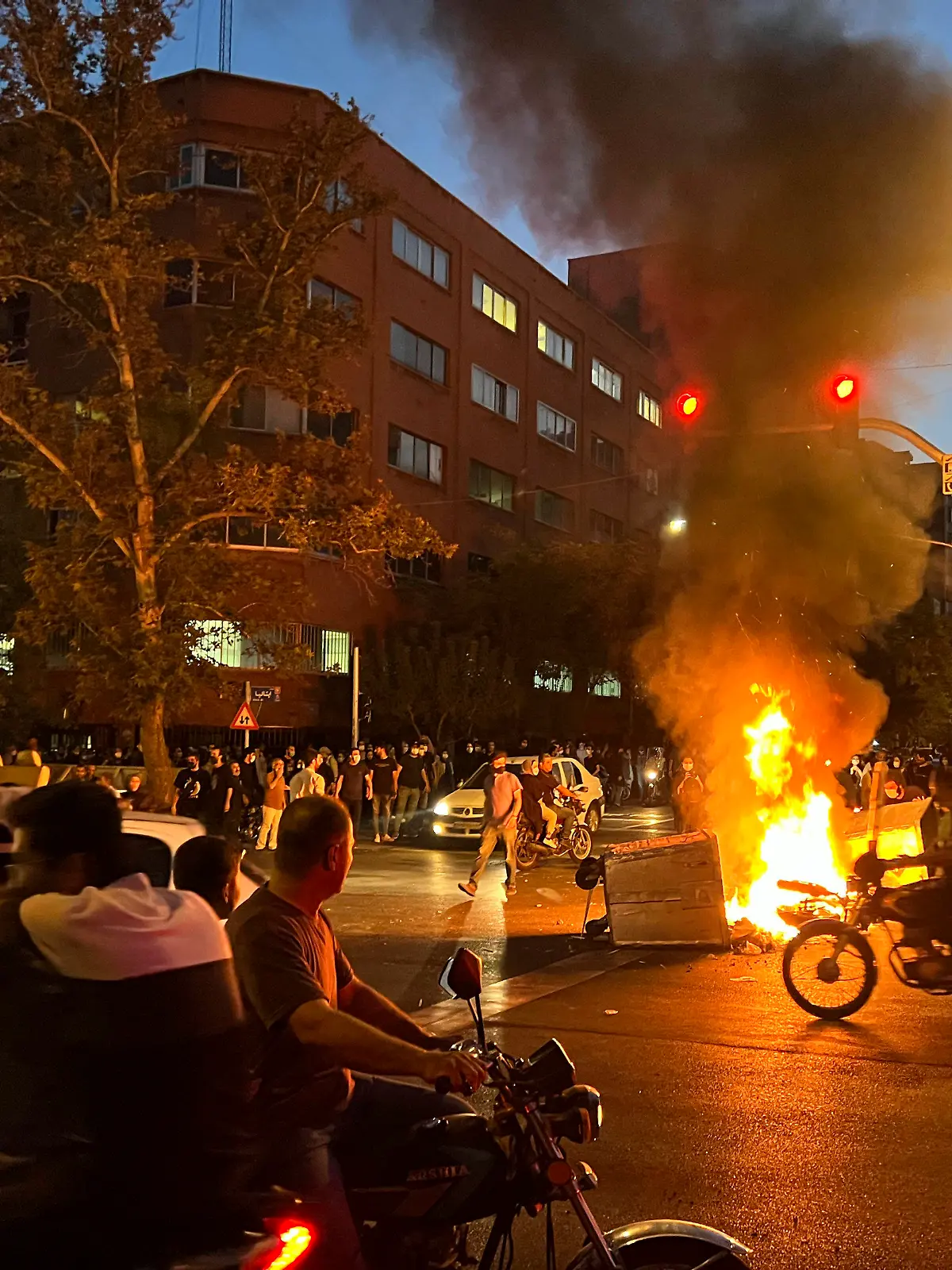 19.09.2022, Iran, Teheran: Auf diesem Foto vom Montag, 19. September 2022, das von einer nicht bei Associated Press angestellten Person aufgenommen und von AP außerhalb des Irans beschafft wurde, brennen ein Polizeimotorrad und ein Mülleimer während eines Protests gegen den Tod von Mahsa Amini, einer 22-jährigen Frau, die von der Sittenpolizei des Landes inhaftiert worden war, in der Innenstadt von Teheran. Studierende haben an verschiedenen Universitäten im Iran ihren Protest gegen den repressiven Führungskurs des Landes fortgesetzt. An mehreren Hochschulen der Hauptstadt Teheran zeigten junge Frauen und Männer am Montag ihren Unmut gegen das islamische Regierungssystem, wie iranische Medien berichteten. Foto: Uncredited/AP/dpa +++ dpa-Bildfunk +++