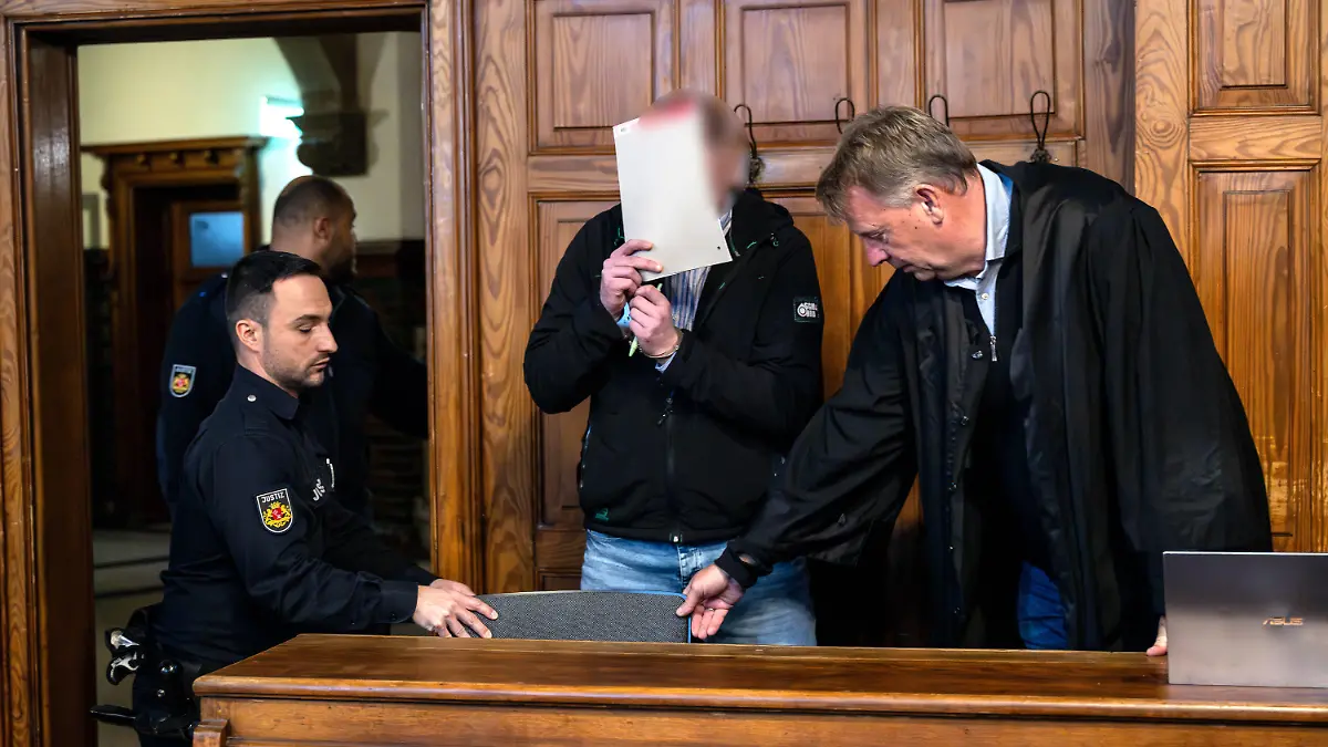 03.11.2023, Bremen: Der Angeklagte steht mit seinem Anwalt Thomas Holle (r) vor Prozessbeginn im Gerichtssaal. Dem 44-Jährigen wird vorgeworfen, eine Frau in Bremen nach einer Feier erwürgt zu haben. Foto: Sina Schuldt/dpa - ACHTUNG: Person wurde aus rechtlichen Gründen gepixelt +++ dpa-Bildfunk +++
