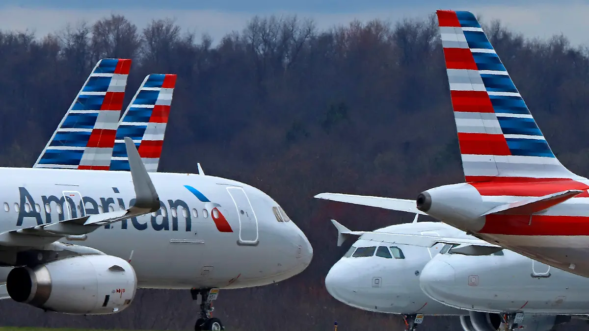 FILE - American Airlines planes sit stored at Pittsburgh International Airport on March 31, 2020, in Imperial, Pa. A jury is deciding that a clothing company should pay more than $1 million to four American Airlines flight attendants who blame chemicals used in the production of their uniforms for causing ailments including rashes and breathing difficulty. Lawyers for the crew members say they represent more than 400 other flight attendants who are making the same claims. Some flight attendants say they had reactions to new uniforms that American gave them in 2016. They sued Twin Hill Acquisition Company and its Tailored Brands division. (AP Photo/Gene J. Puskar, File)