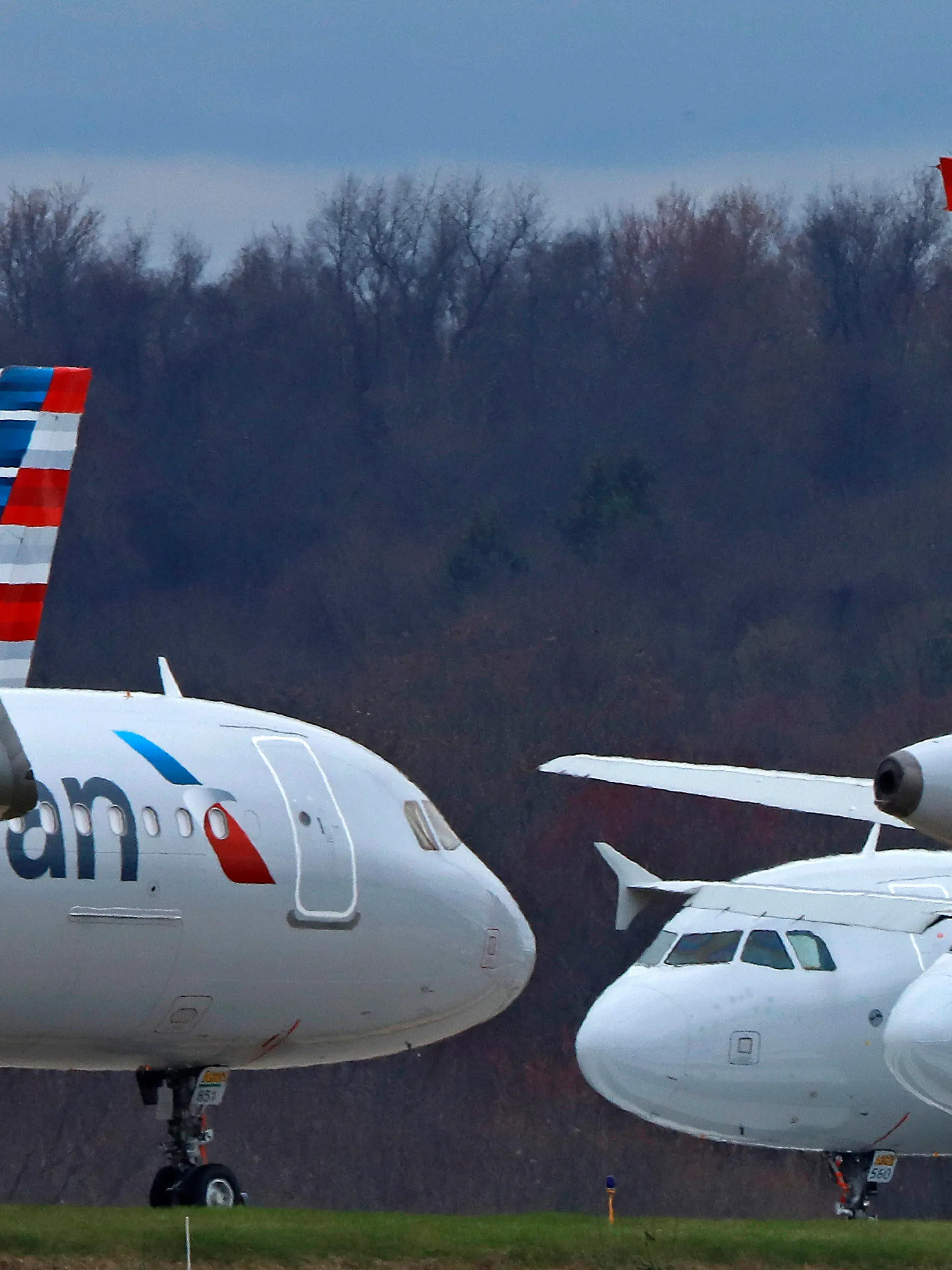 FILE - American Airlines planes sit stored at Pittsburgh International Airport on March 31, 2020, in Imperial, Pa. A jury is deciding that a clothing company should pay more than $1 million to four American Airlines flight attendants who blame chemicals used in the production of their uniforms for causing ailments including rashes and breathing difficulty. Lawyers for the crew members say they represent more than 400 other flight attendants who are making the same claims. Some flight attendants say they had reactions to new uniforms that American gave them in 2016. They sued Twin Hill Acquisition Company and its Tailored Brands division. (AP Photo/Gene J. Puskar, File)