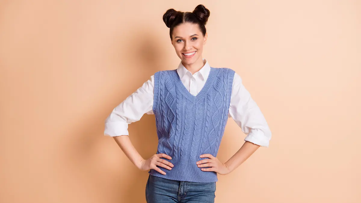 Frau, die eine lila Strickweste trägt und posiert.