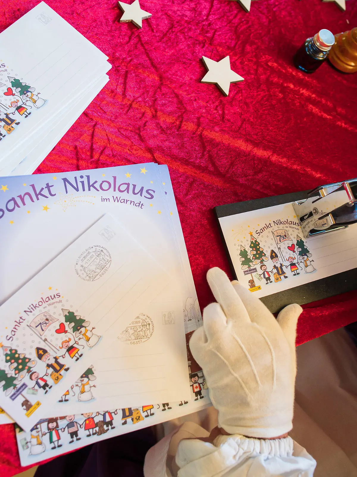 ARCHIV - 05.12.2020, Saarland, St. Nikolaus: Der Nikolaus stempelt in der Nikolaushütte beim Nikolauspostamt im saarländischen St. Nikolaus einen Brief ab. (zu dpa «Kinder wünschen sich Frieden vom Nikolaus») Foto: Oliver Dietze/dpa +++ dpa-Bildfunk +++