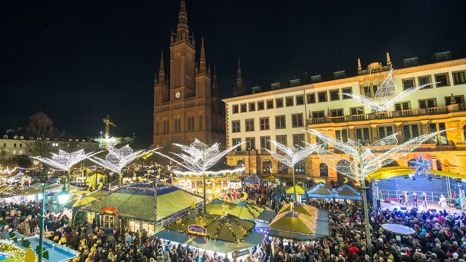 Der gut besuchte Weihnachtsmarkt in Wiesbaden, im Hintergrund die Marktkirche.