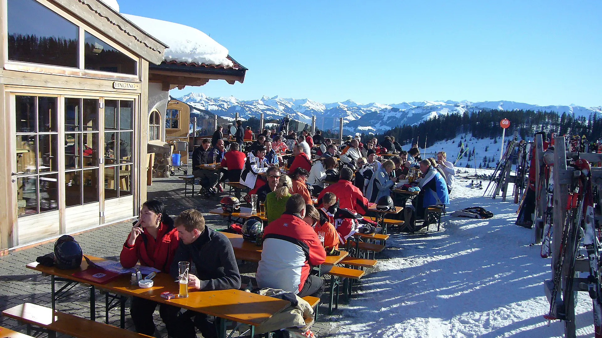 Skifahrer,Skilaeufer im Skigebiet Ellmau / geniessen einen herrlichen Wintertag mit Sonnenschein,Sonne auf einer Terrasse einer Skihuette,Bergalm,Alm,essen und trinken,Speisen.Restaurant.Urlaub,Skiurlaub,Winter,Freizeit,Sport und Erholung.12.01.2009.