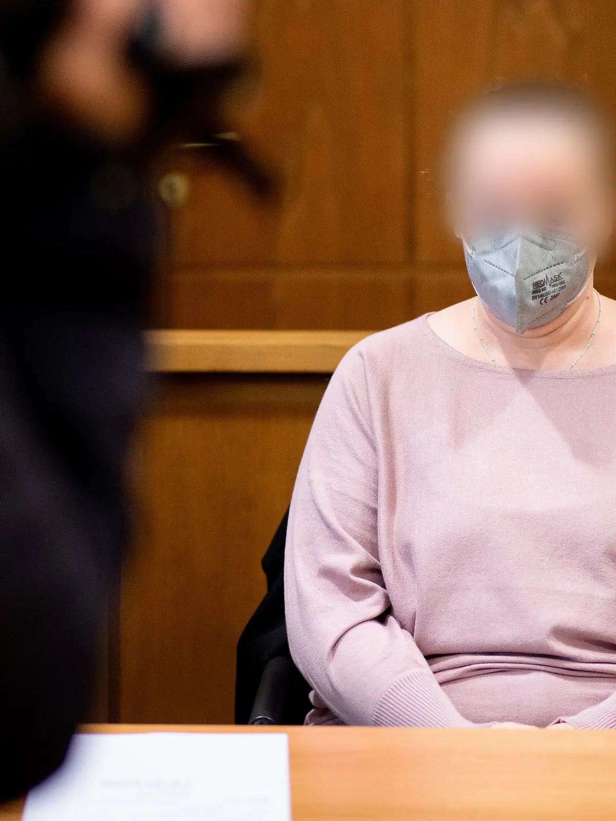 02.11.2022, Niedersachsen, Oldenburg: Die Angeklagte sitzt vor Prozessbeginn in einem Saal im Landgericht. Der angeklagten Frau wird Körperverletzung in 15 Fällen vorgeworfen. Laut Anklage soll die damalige Krankenschwester im April 2021 insgesamt 15 Spritzen entweder ausschließlich mit Kochsalzlösung aufgezogen oder den Impfstoff stark mit der Lösung verdünnt haben. Foto: Hauke-Christian Dittrich/dpa - ACHTUNG: Angeklagte wurde aus persönlichkeitsrechtlichen Gründen auf Anordnung des Gerichts gepixelt +++ dpa-Bildfunk +++
