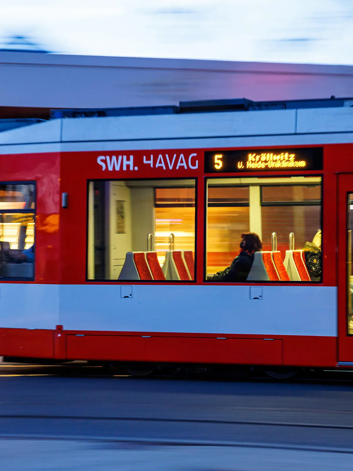 ARCHIV - 27.04.2022, Sachsen-Anhalt, Halle/Saale: Fahrgäste sitzen im morgendlichen Berufsverkehr in einer Straßenbahn in Halle. (zu dpa «Grüne fordern Masterplan für Nahverkehr in Sachsen-Anhalt») Foto: Jens Schlüter/dpa +++ dpa-Bildfunk +++