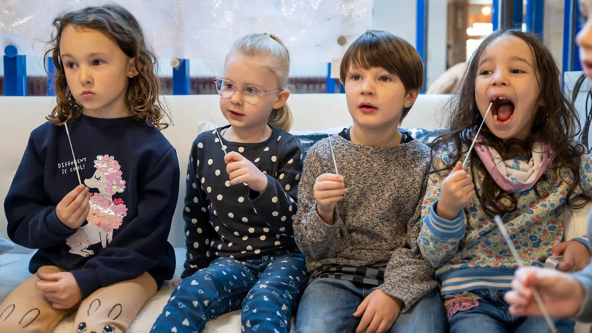 11.01.2022, Bayern, Augsburg: Die Kinder in einer Kindertagesstätte machen am Vormittag eine Corona-Pooltestung (Lollitest), die nun regelmäßig durchgeführt werden soll. Am Montag, 10.01.2022 haben in Bayern die Schulen und auch die meisten Kindertagesstätten wieder geöffnet - mit Änderungen bei den Vorgaben zu Corona-Tests für Krippen- und Kindergartenkinder. Foto: Peter Kneffel/dpa - ACHTUNG: Nur zur redaktionellen Verwendung im Zusammenhang mit einer Berichterstattung über diesen Termin und nur mit vollständiger Nennung des vorstehenden Credits +++ dpa-Bildfunk +++