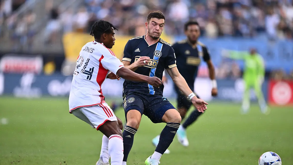Oct 28, 2023; Philadelphia, PA, USA; Philadelphia Union defender Kai Wagner (27) passes the ball away from New England Revolution forward DeJuan Jones (24) during the first half in game one in a round one match of the 2023 MLS Cup Playoffs at Subaru Park. Mandatory Credit: Kyle Ross-USA TODAY Sports