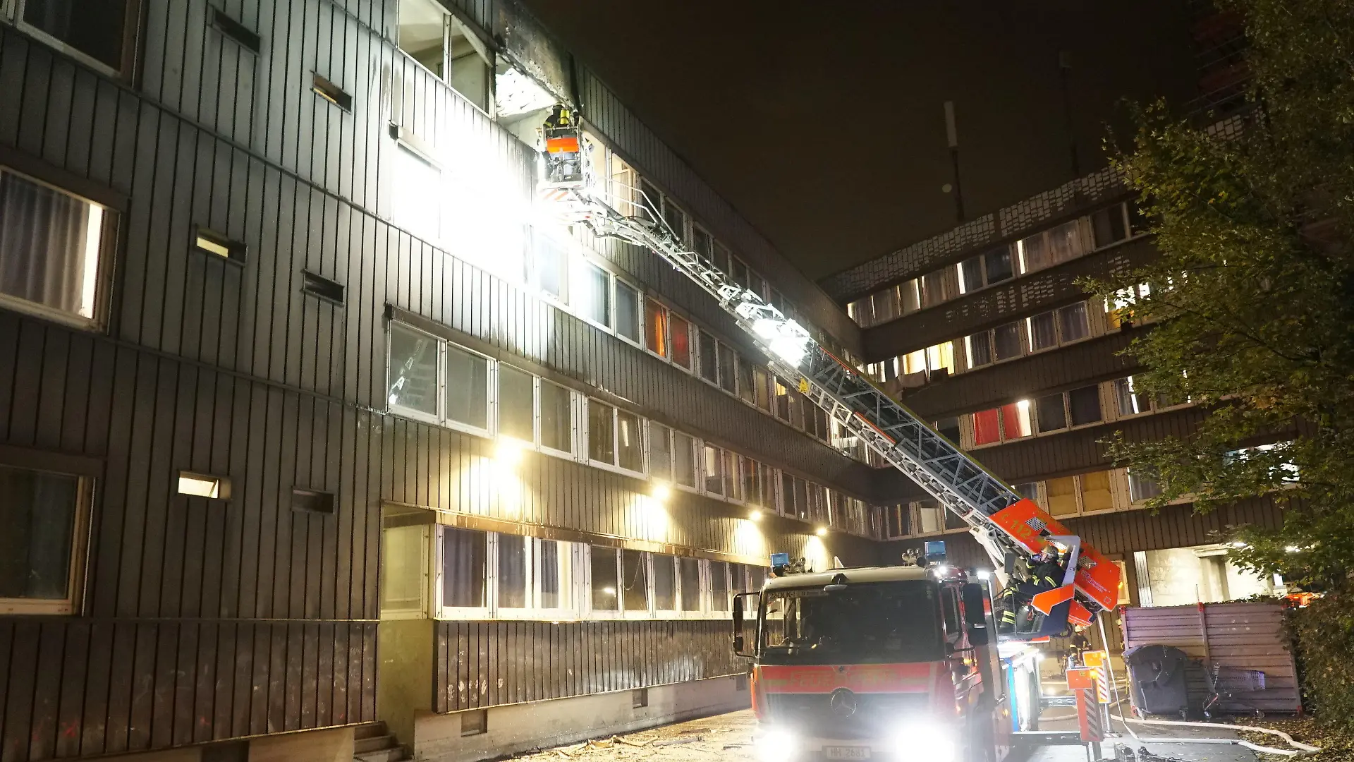 08.11.2023, Hamburg: Einsatzkräfte der Feuerwehr löschen einen Brand in Unterkunft für Geflüchtete. Bei einem Brand in einer Unterkunft für Geflüchtete in Hamburg-Borgfelde hat die Feuerwehr vier Menschen gerettet. Ein Mann sei dabei mit Hilfe einer Drehleiter in Sicherheit gebracht worden, teilte die Feuerwehr mit. Den Angaben zufolge wurden bei dem Brand am Mittwochabend mindestens zwei Menschen leicht verletzt. Das Gebäude wurde evakuiert. Zehn Wohnungen seien nicht mehr bewohnbar. 169 Menschen verließen selbstständig die Unterkunft. Wie hoch der Schaden ist und warum es zu dem Brand kam, war zunächst noch unklar. Foto: Citynewstv/dpa +++ dpa-Bildfunk +++