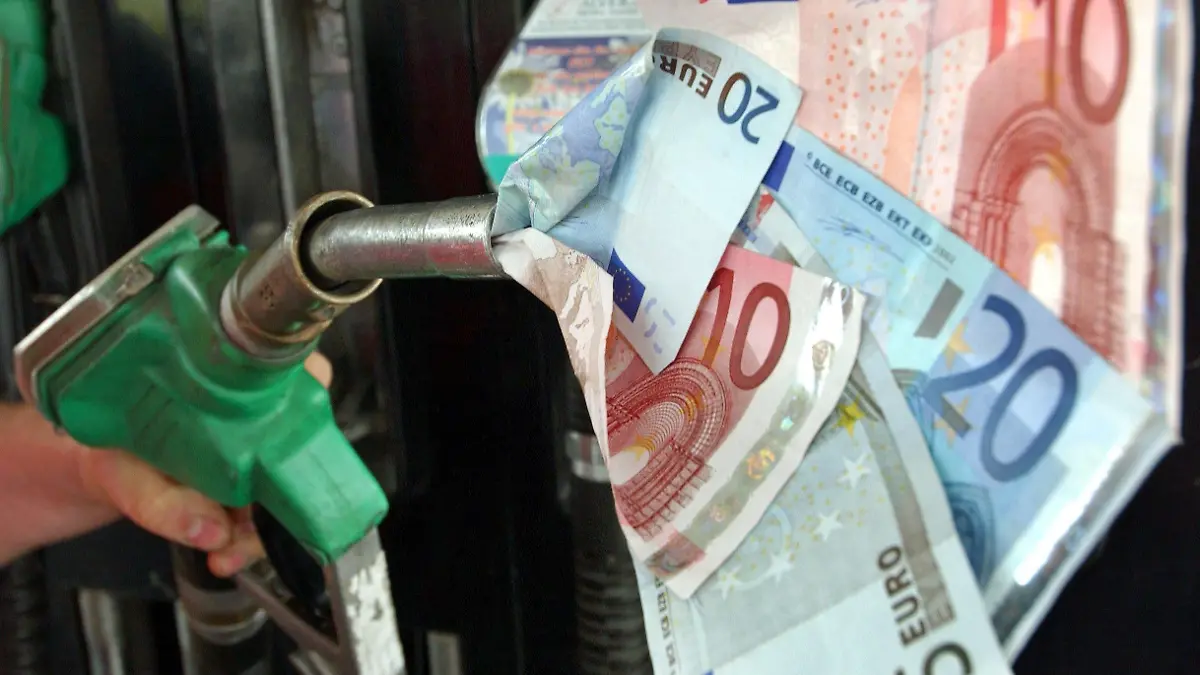 Eine Zapfpistole "saugt" Geldscheine ein (Symbolbild aufgenommen am 10.5.2004 in Frankfurt an der Oder). Der Benzinpreis war zuletzt an deutschen Tankstellen auf ein Rekordhoch von 1,20 Euro für den Liter Super gestiegen. Den schnelleren Anstieg der Benzinpreise gegenüber dem Ölpreis führen Experten auf einen Engpass bei Raffinerien zurück, die Benzin herstellen. Der Benzinpreis an der Tankstelle besteht zu rund 70 Prozent aus Steuern und Abgaben. Die Mineralöl- und Ökosteuern betragen fest 65,5 Cent je Liter und verändern sich nicht, wenn Preise steigen. Auf Preis und Steuern werden 16 Prozent Mehrwertsteuer berechnet. Um den Benzinpreis auf einen Euro je Liter zu senken - wie teils gefordert - müsste der Staat auf rund 13 Milliarden Euro Einnahmen verzichten.