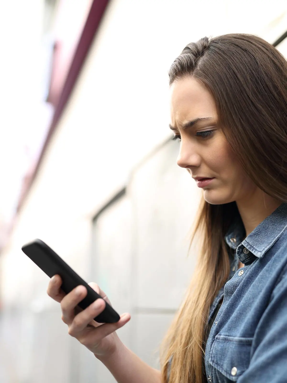  Sad woman checking smart phone content in the street ,model released, Symbolfoto PUBLICATIONxINxGERxSUIxAUTxONLY Copyright: xAntonioGuillemx Panthermedia26834141