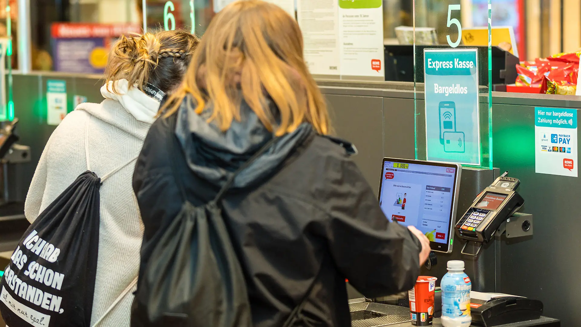 Kundinnen scannen und bezahlen ihre Einkäufe an einer Selbstbedienungskasse in einem Lebensmittelsupermarkt.