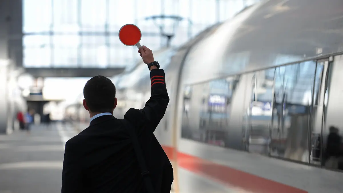 Ein Zugbegleiter gibt am Freitag (07.09.2012) am Hauptbahnhof in München (Oberbayern) das Signal zur Abfahrt. Der flächendeckende Streik der Lufthansa-Flugbegleiter trifft nach Angaben des Unternehmens mehr als 100 000 Passagiere. Foto: Andreas Gebert dpa/lby ++